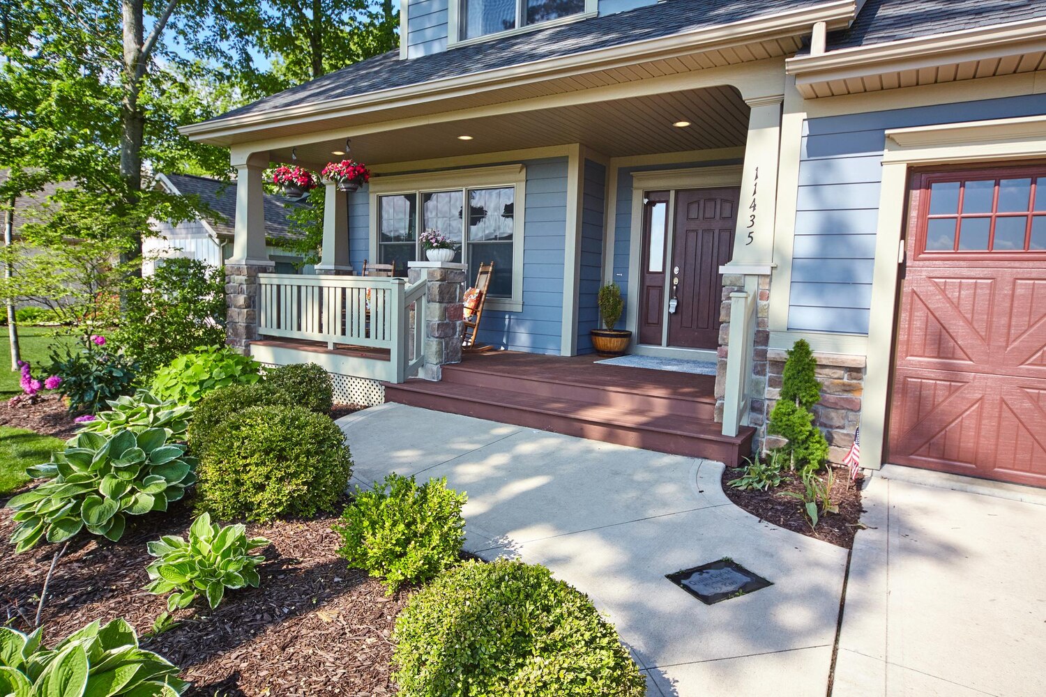 sunlit suburban home with front porch american flag 501731 17059